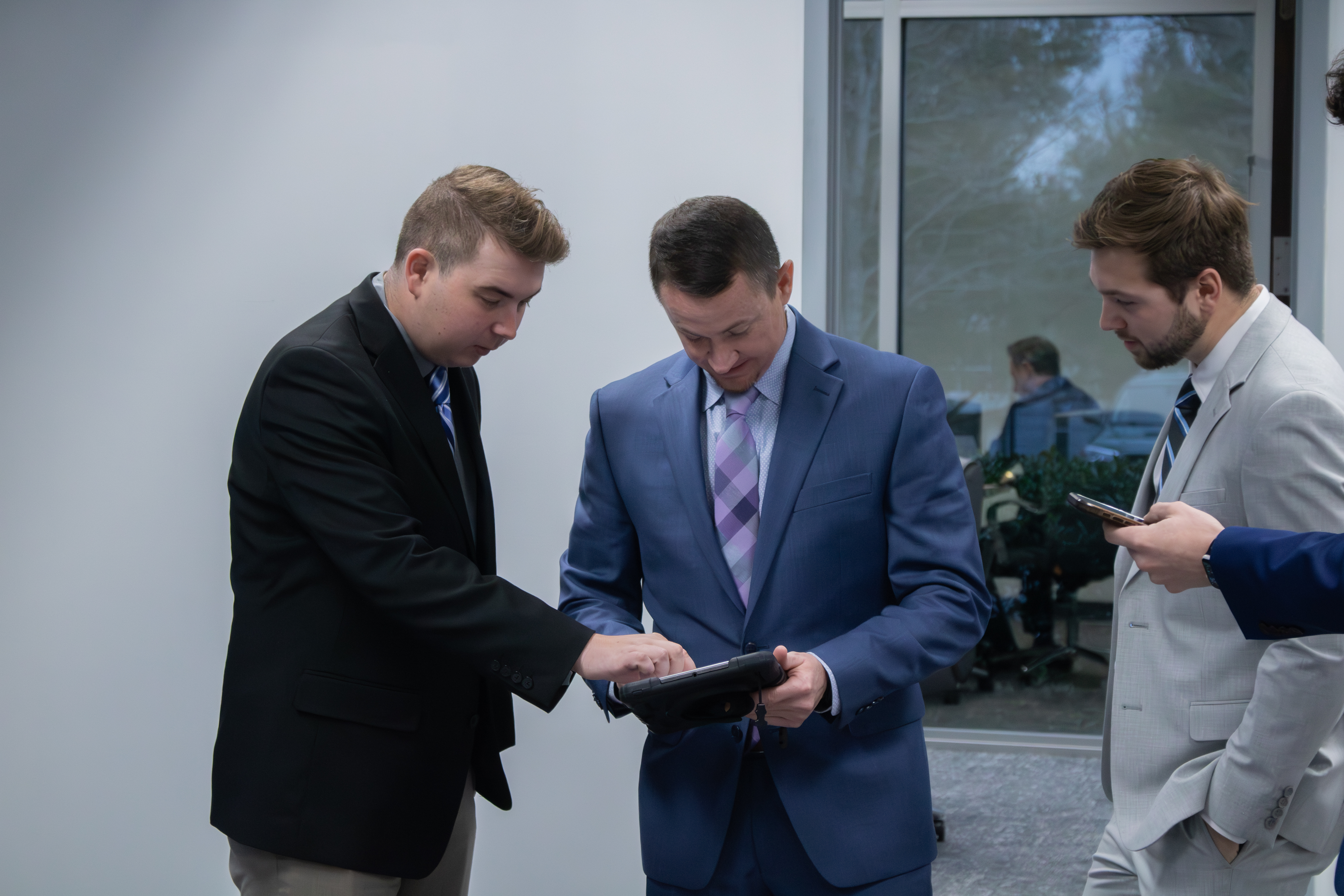 Team members reviewing work together on a tablet
